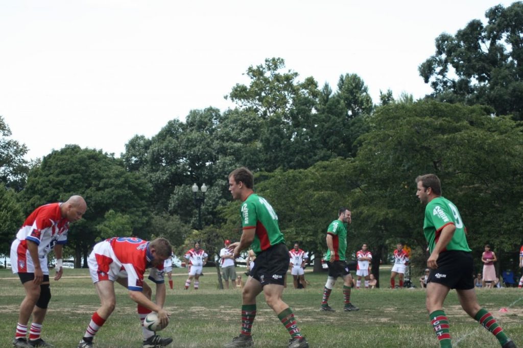 Rugby league player playing the ball back with his foot after a tackle